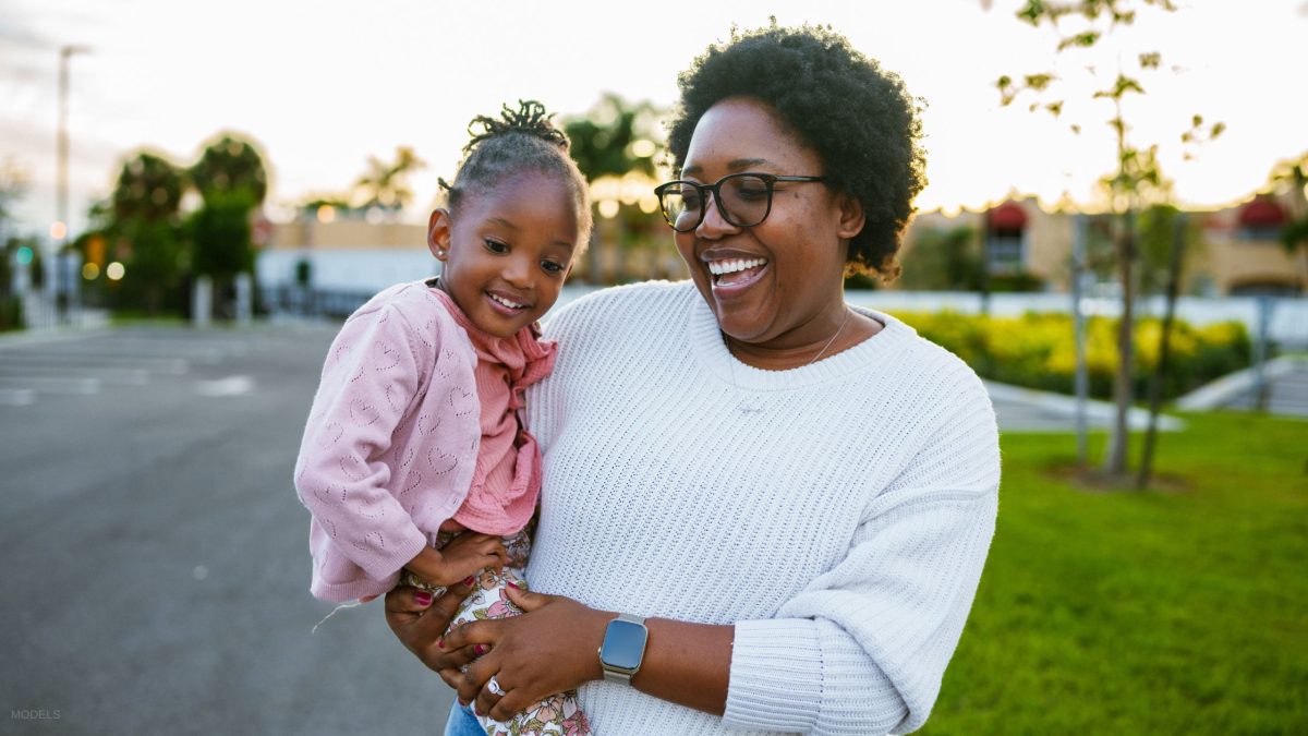 A mother and her child (models) smile and enjoy the sunset together